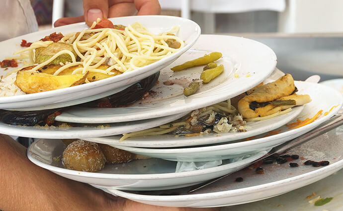Pile of plates with food waste on them